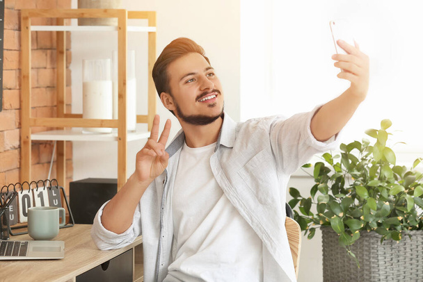 Handsome young man taking selfie at home - Foto, Imagem