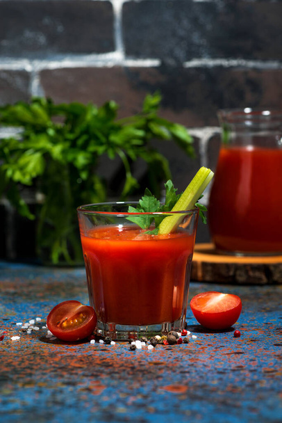 healthy tomato juice with salt and celery on dark background, vertical - Фото, зображення