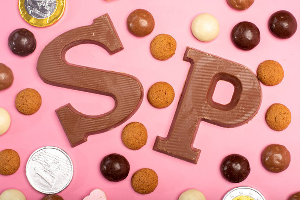フラットレイコンセプト, St.Nicholas 12月の日,オランダの子供の休日,ベルギー,ドイツとキュラソー,チョコレート文字でピンクの背景,コインやスパイシーなクッキー - 写真・画像