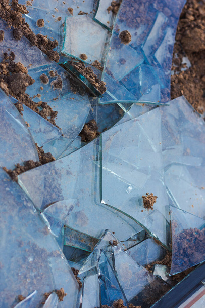 Una ventana rota en el suelo. Fondo de vidrio roto. Fragmentos. - Foto, imagen