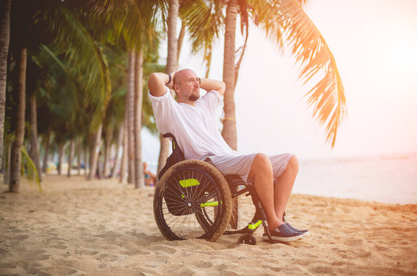 Disabled man in a wheelchair on the beach. - Foto, Bild