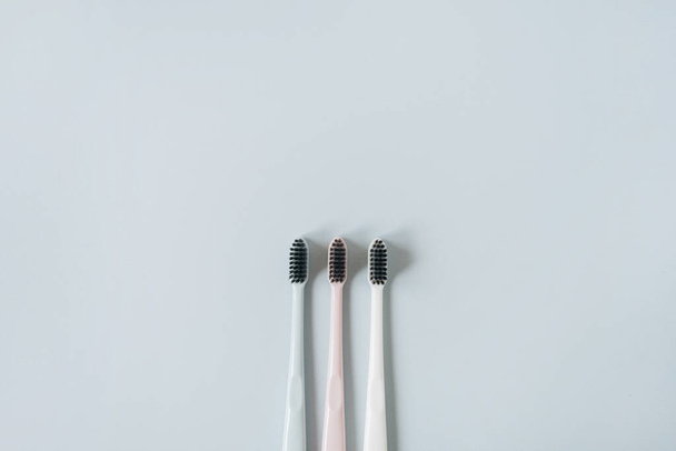 Escovas de dentes no fundo azul. Flat lay, vista superior cuidados orais mínimos, conceito de higiene dental
 - Foto, Imagem