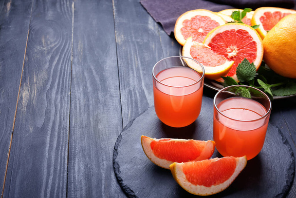 Glasses of fresh grapefruit juice on table - Foto, imagen