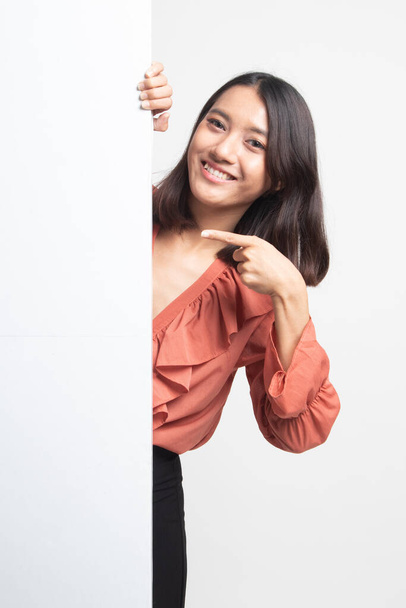 Young Asian woman point to a  blank sign on white background - 写真・画像