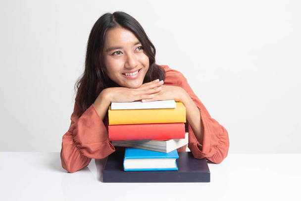 Happy young Asian woman read a book with books on table on white background - 写真・画像
