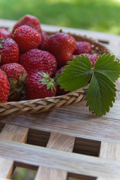 Strawberry in a wattled basket on a table - Φωτογραφία, εικόνα
