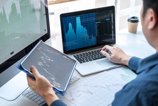 Stock exchange market concept, stock broker looking at graph working and analyzing with display screen, pointing on the data presented and deal on a exchange, Businessman trading stocks online. - Fotoğraf, Görsel