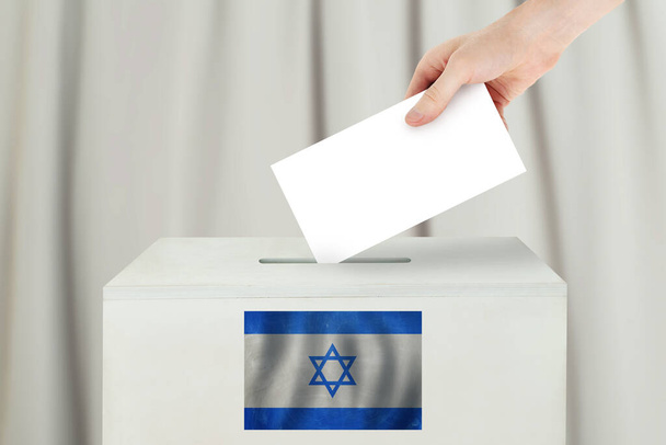 Izraeli szavazási koncepció. Szavazólapot tartó választópolgár a szavazóhelyiségben - Fotó, kép