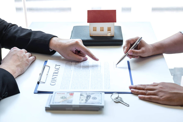 不動産仲介業者は、承認された抵当申請書、住宅ローンの申込みのための住宅ローンの提供に関する契約書に顧客の署名契約書に契約書を指す. - 写真・画像