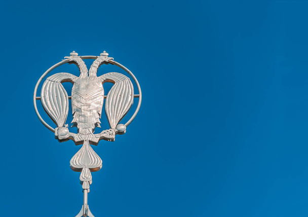 Coat of arms of Russia, silver double-headed eagle against the background of blue sky. Silver Russian heraldic symbol, background with copy space. - Fotografie, Obrázek