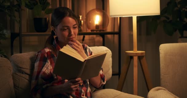 Mujer sensible llorando mientras lee libro por la noche
 - Metraje, vídeo