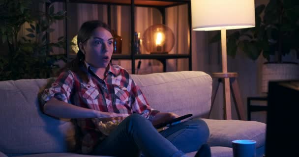 Woman feeling scared watching tv at night - Footage, Video