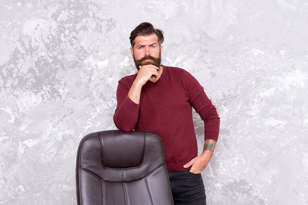 Beard trend is not over. Bearded man stand at office chair. Trendy hipster wear casual style. Mens fashion trend. Trendy style. Menswear trend. Trend for professionals - Фото, зображення