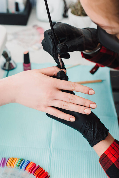 Manicurist at work, beaty manicure nails. Manicure process. Closeup photo shoot of manicure process at beaty studio. - Foto, Bild