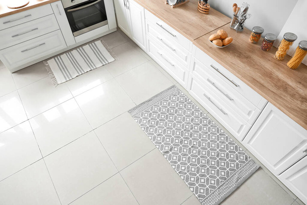 Stijlvol tapijt op de vloer in de moderne keuken - Foto, afbeelding