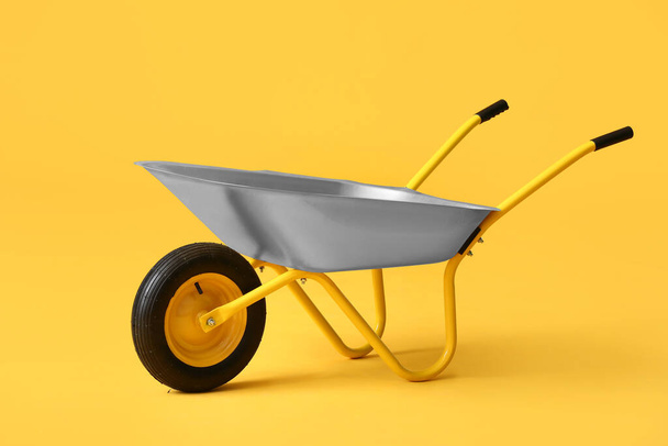 Empty wheelbarrow on color background - Photo, Image