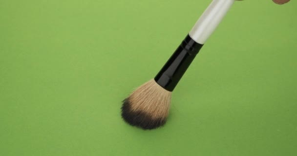 Vertical movement of the brush for makeup on a green background. - Footage, Video