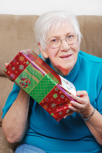 Happy senior woman shaking her christmas present - Zdjęcie, obraz