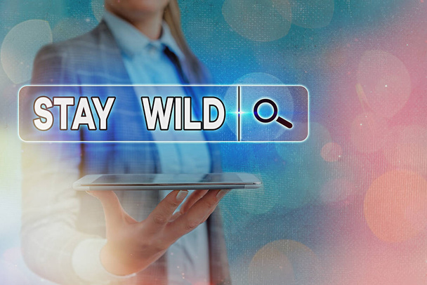 Textschild mit der Aufschrift Stay Wild. Konzeptfotos sind den ganzen Tag über extrem energiegeladen. - Foto, Bild