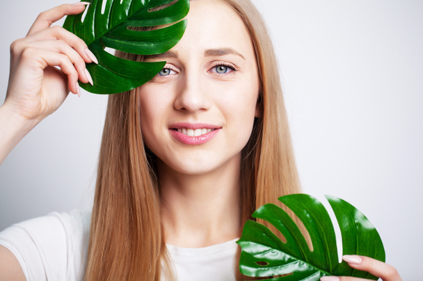 Gyönyörű lány egészséges bőr és zöld növény - Fotó, kép