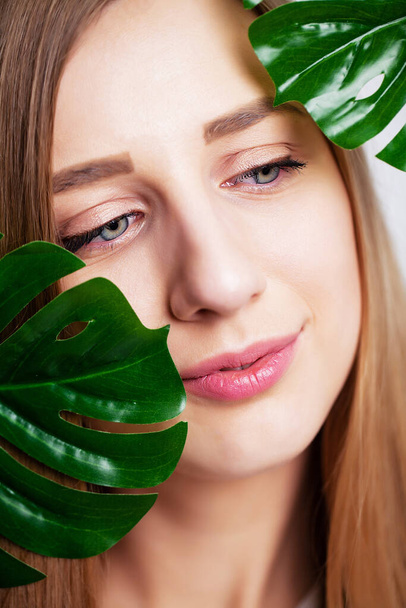 Beautiful girl with healthy skin and green plant - Zdjęcie, obraz