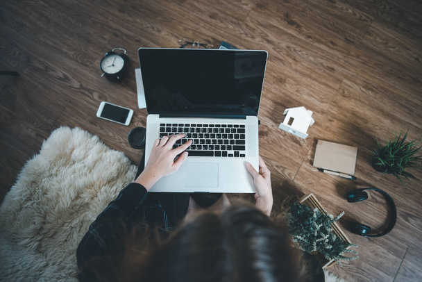 Εργασία από το σπίτι για την κοινωνική αποστασιοποίηση στο Coronavirus Covid-19 Κατάσταση, Γυναίκα Designer Χρησιμοποιώντας Laptop στο πάτωμα χαλί στο σπίτι της. Above View of Creative Design Woman is Working Online at Home - Φωτογραφία, εικόνα