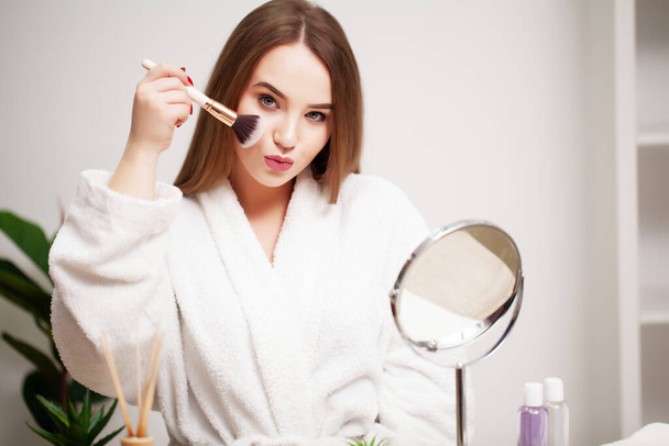 Beautiful girl with healthy skin makes makeup - Photo, Image