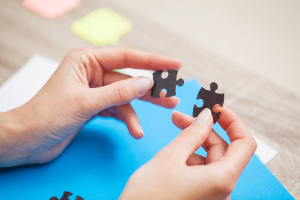 Conceito de negócio, mãos femininas compõem um quebra-cabeça simbolizando o sucesso da empresa
 - Foto, Imagem