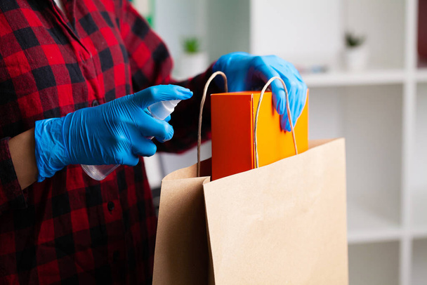 Frau in Handschuhen desinfiziert Produktverpackungen in Wohnung - Foto, Bild