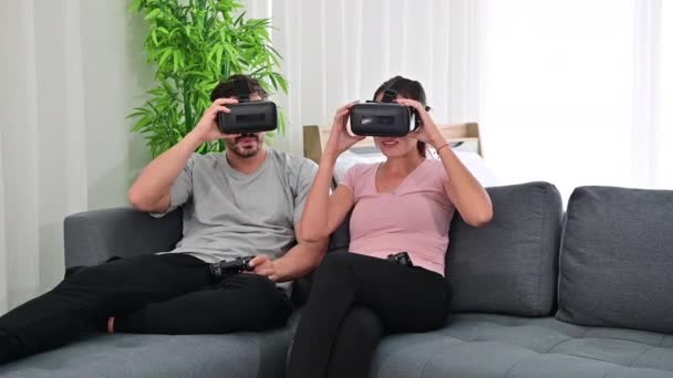 4K Fiatal boldog pár játszik videojátékok viselő virtuális valóság szemüveg - Felvétel, videó