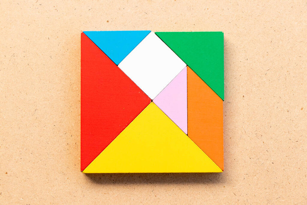 Barva tangram puzzle ve čtvercovém tvaru na dřevěném pozadí - Fotografie, Obrázek