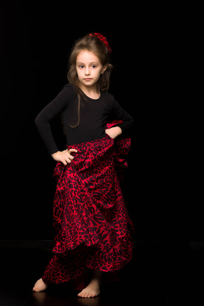 Dziewczyna tancerka w czerni i czerwieni sukienka Wykonywanie na czarnym tle - Zdjęcie, obraz