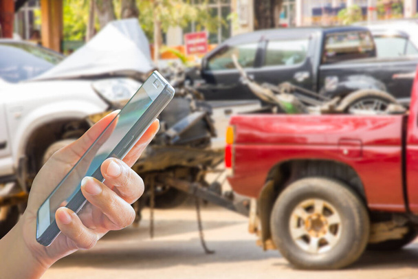 person use mobile phone contact insurance or family ,blur image of tow truck delivers the damaged vehicle by accident - Photo, Image