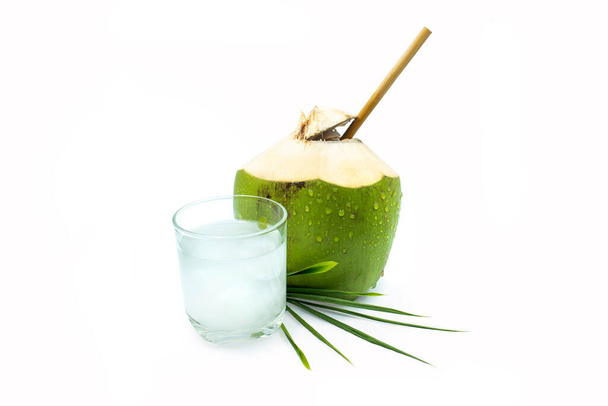 Un bicchiere di acqua di cocco con noce di cocco verde su fondo bianco - Foto, immagini