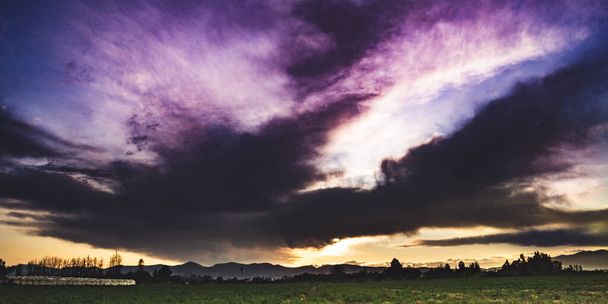 Puesta de sol púrpura con nubes increíbles
 - Foto, Imagen