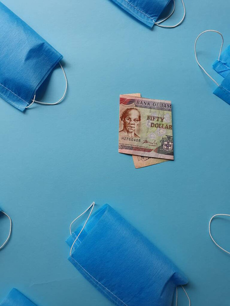 Jamajski banknot 50 dolarów i maski na niebieskim tle - Zdjęcie, obraz