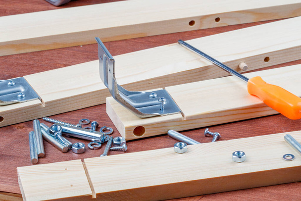 o processo de montagem de móveis de madeira com suas próprias mãos ferramentas e parafusos sobre os detalhes. montagem de mobiliário em casa sozinho
 - Foto, Imagem