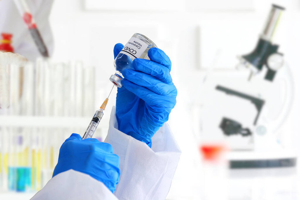 výzkumník, vědec, lékař nebo chemik v ochranném obleku používají injekční stříkačky vakuové vakcíny k testování s ošetřením viru civid s laboratorním zázemím. - Fotografie, Obrázek