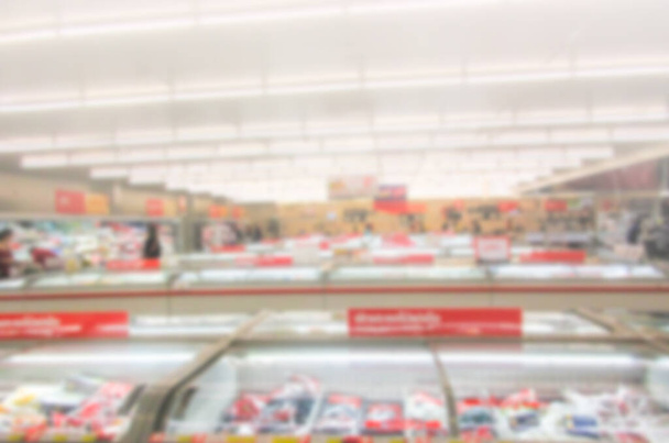 Размытие для фона супермаркета в Таиланде. Огромный стеклянный проход с разнообразной упаковкой обработанной пиццы. Морозильник полный ассортимент замороженных продуктов в супермаркете
 - Фото, изображение