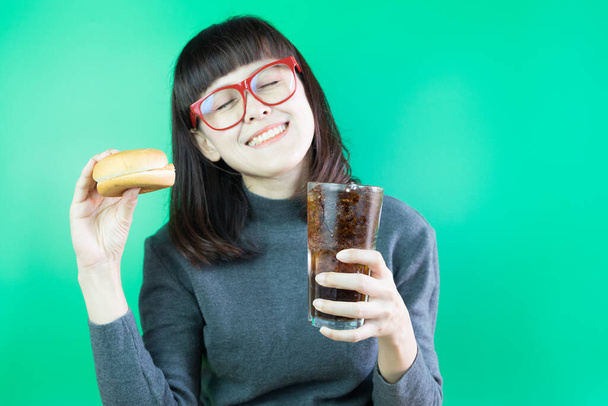 Onnellisuus nainen kädet pitämällä lasi colaa jäällä ja hampurilainen. Nauti syöminen käsite - Valokuva, kuva