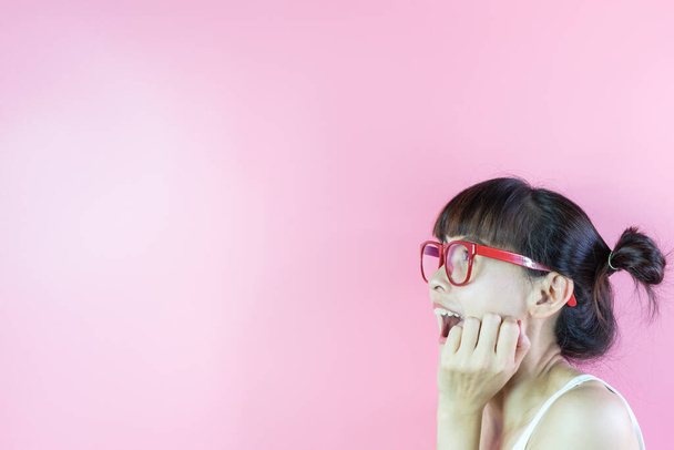 Αστεία γυναίκα με γυαλιά έκπληκτος χαρούμενος και κοιτάζοντας χώρο αντίγραφο σε ροζ φόντο. - Φωτογραφία, εικόνα