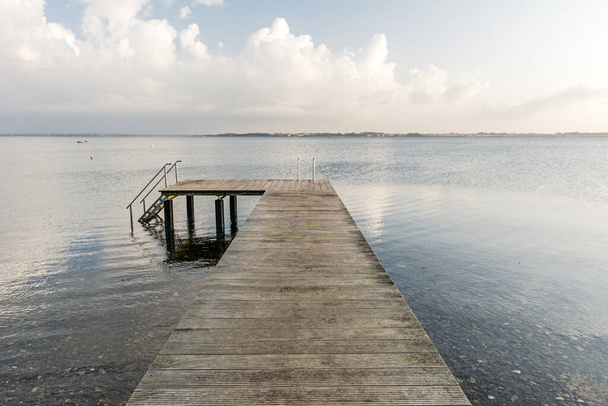Muelle de madera en el tranquilo mar Báltico a la luz de la mañana
 - Foto, Imagen