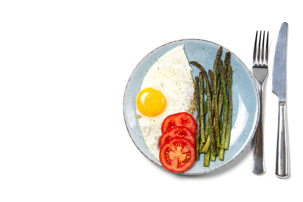 Здоровый домашний завтрак со спаржей, жареным яйцом и рукколой. концепция карантина здорового питания. кето-диета. - Фото, изображение