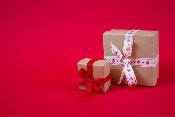 Natal fundo vermelho witn pequenas caixas de presente artesanais com espaço de cópia
 - Foto, Imagem