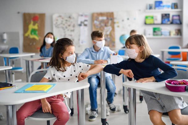 Children with face mask back at school after covid-19 quarantine and lockdown, greeting. - Φωτογραφία, εικόνα