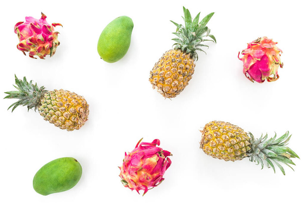 Τροπικό μοτίβο φρούτων με ανανά, μάνγκο και φρούτα δράκου σε λευκό φόντο. Επίπεδο lay, πάνω όψη - Φωτογραφία, εικόνα