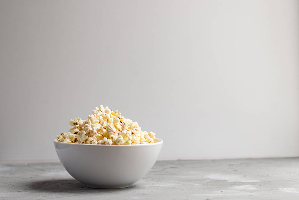 popcorn in una ciotola bianca sul tavolo grigio. Copyspace
 - Foto, immagini
