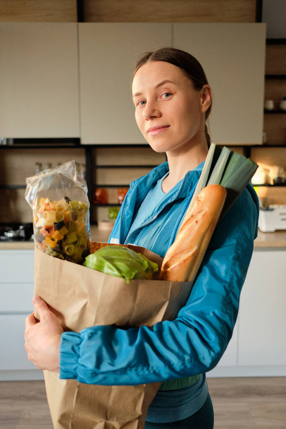 Mujer joven y saludable con bolsas de compras en casa
 - Foto, imagen
