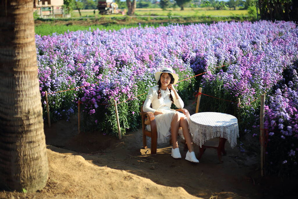 Μια γυναίκα κάθεται σε μια καρέκλα στον κήπο Mae Rim, Chiang Mai, Ταϊλάνδη - Φωτογραφία, εικόνα