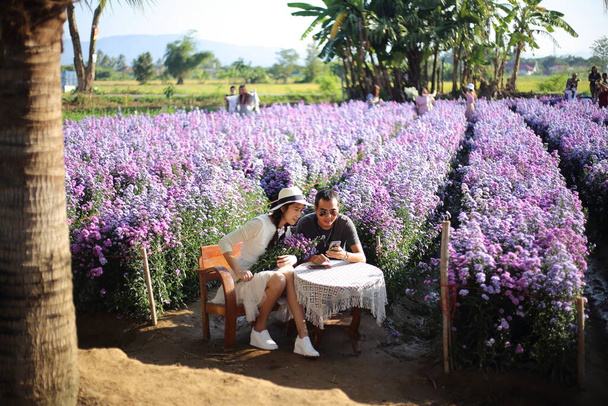 Mężczyźni dają kwiaty kobietom w ogrodzie Mae Rim, Chiang Mai, Tajlandia - Zdjęcie, obraz